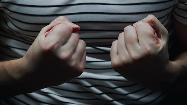 The man clenched his fist and is displaying aggression.