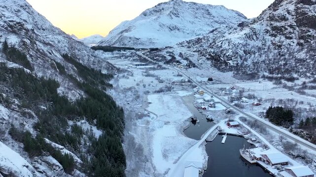 Snowy fishing harbor and mountain slopes at Napp in Lofoten, Norway.
