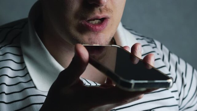 A voice message on the phone.
A man is recording a voice message or talking on the phone.