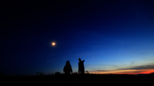 Amateur astronomers enjoying night sky with stars, planets, Moon eclipse and other celestial objects.