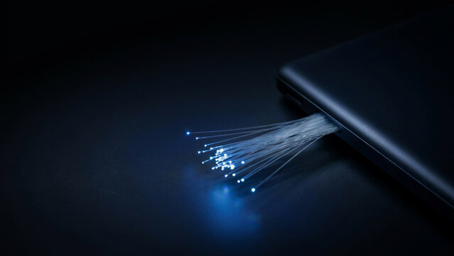 Fiber optic cable glowing with blue light against dark background data transmission optical cable network connection high speed internet technology communication