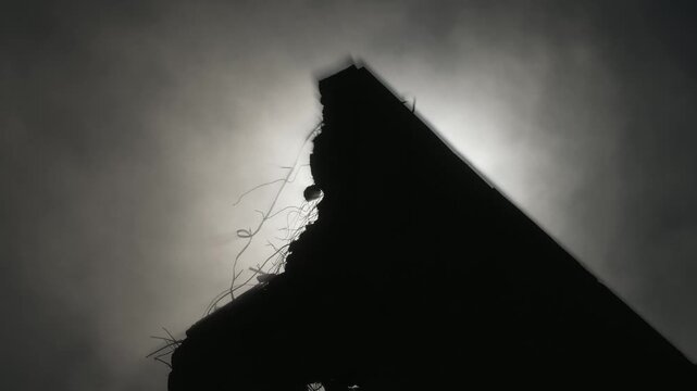 Artistic view of a crane demolishing a multi-story building in sunny weather.