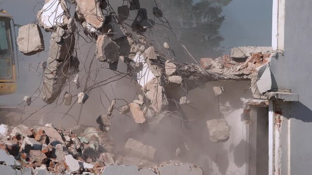 A crane demolishing a multi-story building in sunny weather.