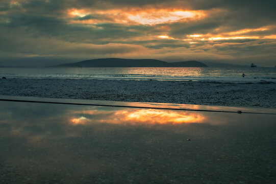 View of the sunset reflecting on a wet surface at Middleton Beach, Western Australia, Australia.
