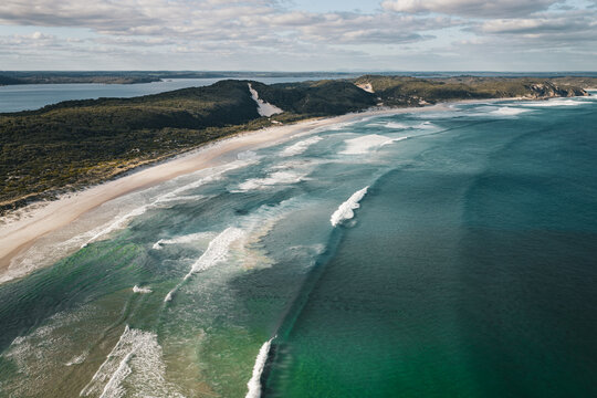 View of Middleton Beach with turquoise ocean waves, sandy shoreline, and lush coastal vegetation in Middleton Beach, Western Australia, Australia.