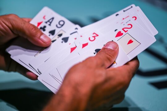 View of a person holding a fan of playing cards during a game in Estoril, Lisboa, Portugal.