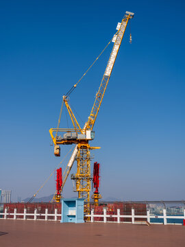 View of a yellow construction crane standing against a clear blue sky at a development site in Busan, Busan, South Korea.