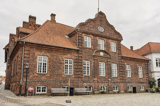 Viborg, Denmark - 07 August 2026: View of Friendenreichs Gard in Nytorv Square featuring historic red brick architecture with a gabled roof and white-framed windows.