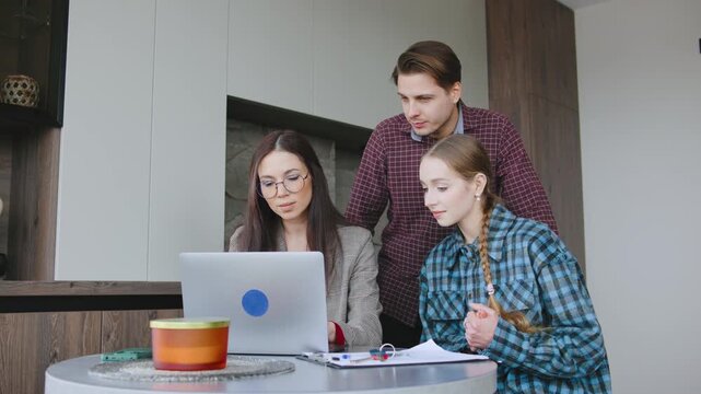 Rieltor helps family with moving process and buying a home while seated at a table with cardboard boxes nearby