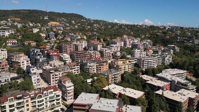 Aerial view of residential coastal neighborhood on green hill landscape