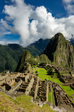 Urubamba Province, Peru - 17 March 2025: View of Historic Sanctuary of Machu Picchu with ancient stone ruins, green terraces, and towering Andean peaks under a cloudy sky.