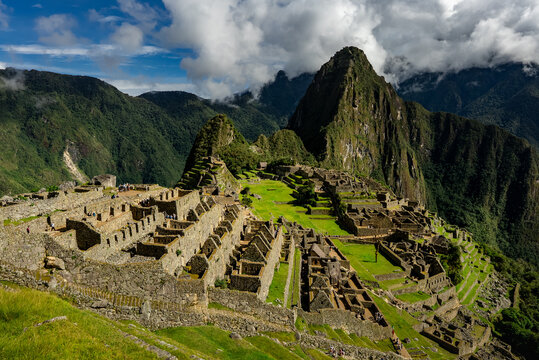 Urubamba Province, Cusco, Peru - 17 March 2025: View of the Historic Sanctuary of Machu Picchu with ancient stone ruins, green terraces, and the towering Huayna Picchu mountain.