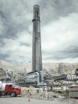 Chimney of the smelter, in the foreground a spoil heap contaminated with heavy metal residues, La Oroya, Peru