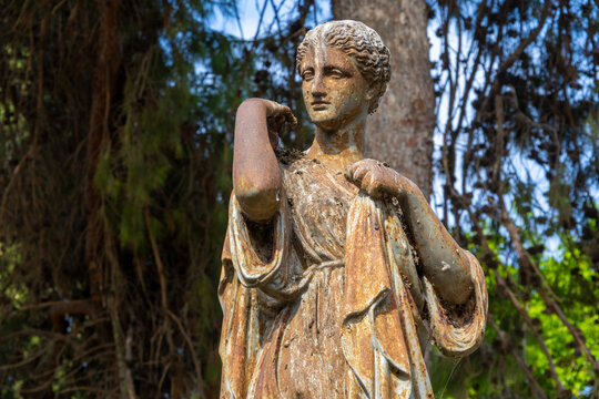 Weathered vintage iron statue of a classical female figure in San Anton Gardens