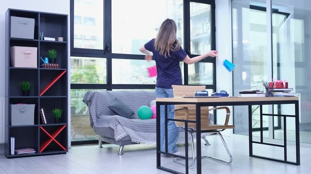 Delighted woman dances joyfully holding colorful shopping bags. Female holds shopping packages filled with attractive new clothes and useful items
