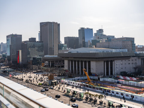 Seoul, South Korea - 21 February 2026: View of Sejong Center for the Performing Arts surrounded by modern skyscrapers, busy streets, and pedestrians in the city center.