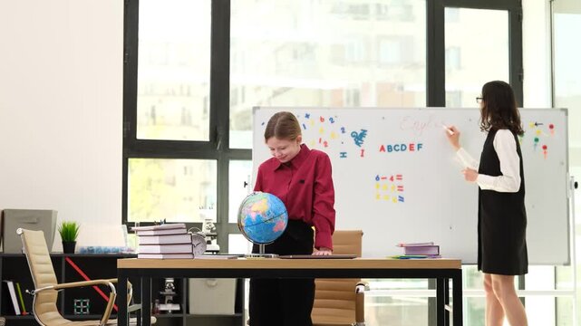 Geography teacher writes lesson topic in neat large letters on whiteboard. Sleepy student spins globe and yawns with barely concealed boredom