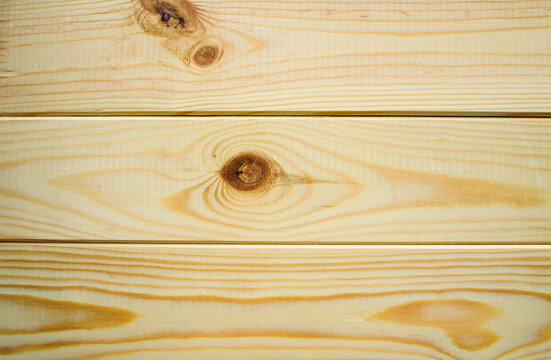 Wooden texture background. Light beige pine planks with horizontal grain lines. Round brown knots and smooth natural timber surface with visible wood rings