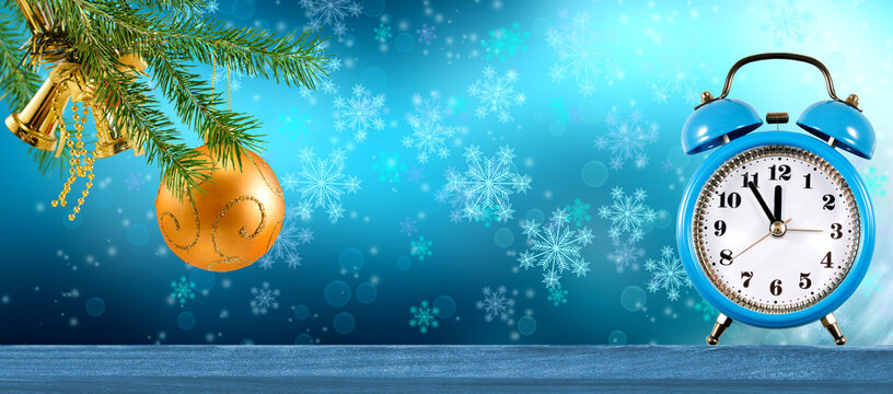 Christmas decorations with a blue alarm clock and ornaments on a winter background