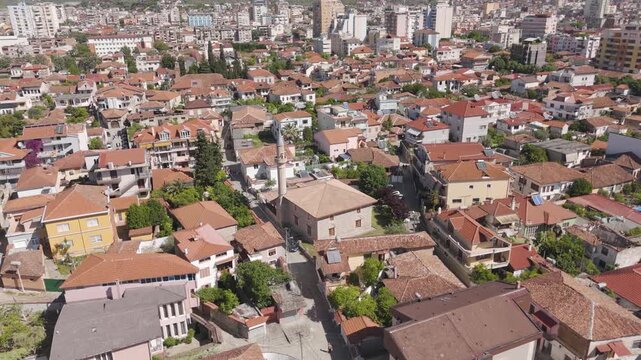 Aerial drone shot orbiting the historic King Mosque, showing the old town district with its red tiled roofs and modern buildings