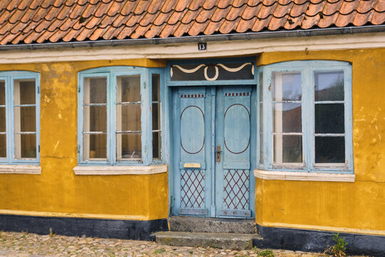 Ribe, Denmark - 20 July 2026: View of colorful doors and blue-framed windows on a vibrant yellow historic house in the old town of Ribe.