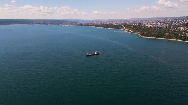 Aerial view of cargo ships and tankers anchored in open calm blue sea waters
