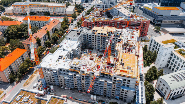Overhead view of a courtyard building under construction. Cranes and timber decking cover upper floors around an open courtyard in Bratislava.