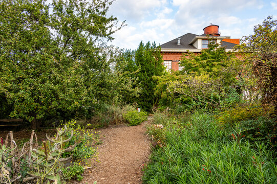 Troutdale, Oregon, United States - 14 September 2026: View of McMenamins Edgefield featuring a garden path leading to the historic brick building and water tower surrounded by lush greenery.
