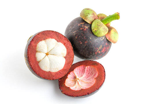 Whole and cut ripe mangosteens showing white segmented arils, isolated on a plain white background.