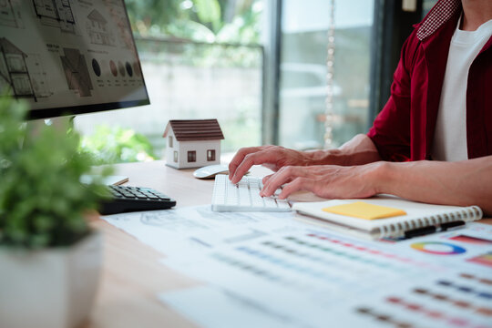 Creative designer reviewing color palettes, architectural concepts, and visual plans on a computer in a modern workspace.