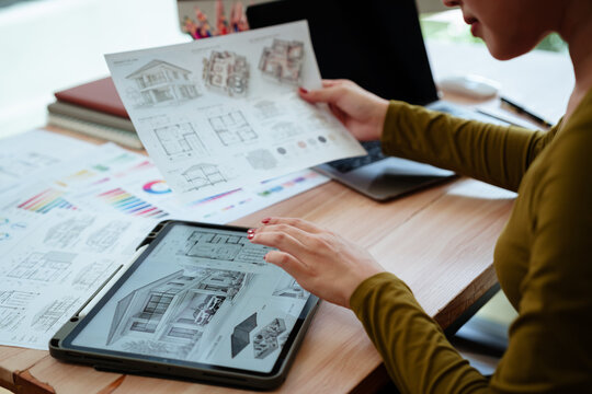 Creative designer reviewing color palettes, architectural concepts, and visual plans on a computer in a modern workspace.
