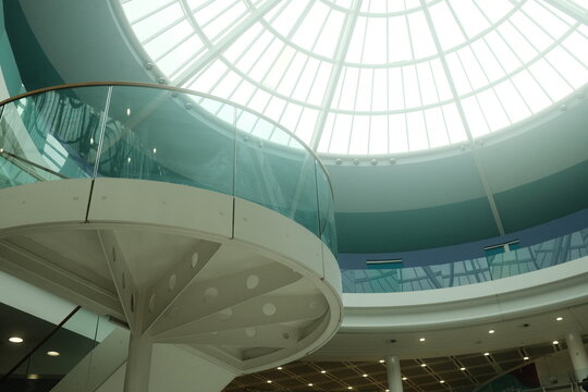 Inverness, Scotland, United Kingdom - 17 September 2026: View of a modern interior featuring a curved glass balcony, a spiral staircase, and a large circular skylight ceiling.