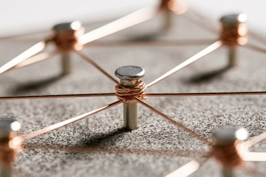 Network of metallic pins and copper wires forming abstract connections