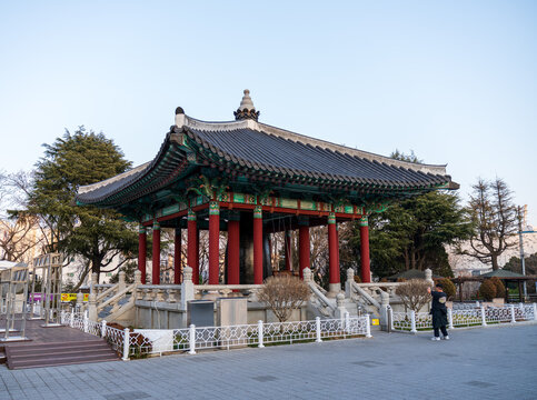 Busan, South Korea - 07 February 2026: View of the traditional pavilion in Yongdusan Park with its ornate tiled roof and red pillars set against a clear sky.