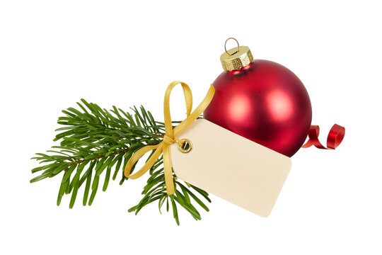 christmas advent decoration with blank empty gift tag or name label for christmas card ornaments with fir tree branch, red christmas ball and ribbon isolated