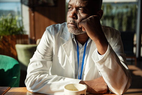 Doctor resting his head and thinking over coffee
