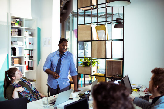 Man leads team discussion in modern office