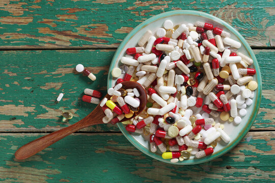 Assorted pills on wooden background