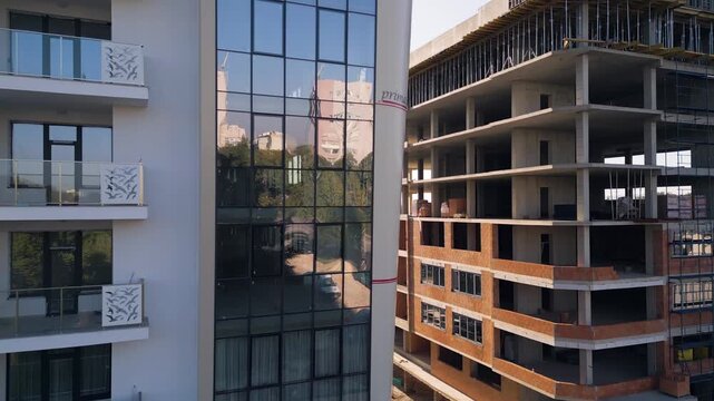 Modern apartment building facade next to construction site under clear sky