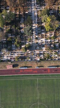Aerial top down view of running track near cemetery representing life and death