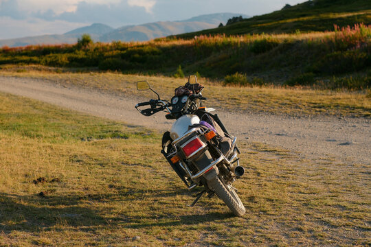 Adventure touring motorcycle parked on side of mountain dirt trail