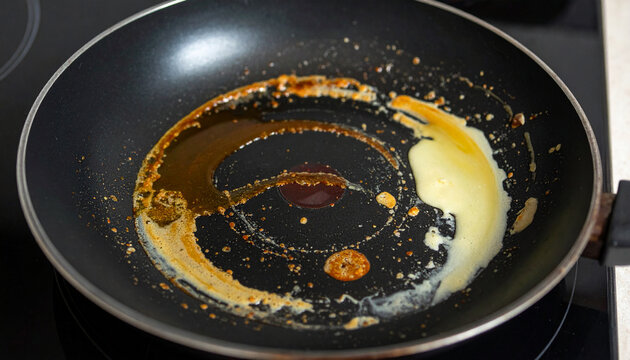 油汚れが残った使用後のフライパンのクローズアップ
Close-up of a used frying pan with greasy residue