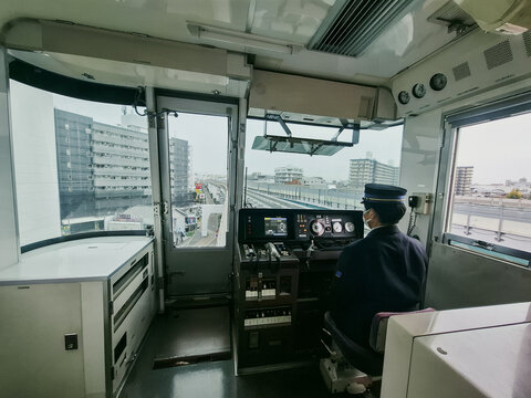 Osaka, Japan - 13 November 2025: View of a train driver operating a train from the cab while traveling through the urban landscape of Osaka.