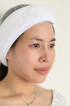 Woman with skincare headband and clear skin in spa or beauty treatment setting