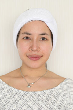 Woman with a white head towel and a gentle smile posing indoor