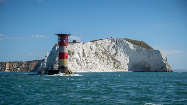 Alum Bay, England, United Kingdom - 05 September 2026: View of The Needles Lighthouse standing against the iconic white chalk cliffs under a clear blue sky.
