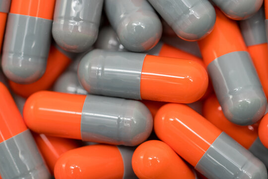red and yellow pills. Top view of orange, grey antibiotic capsule pills. Pharmaceutical industry. Drug production. Pharmacy drugstore background. Global healthcare. Antibiotic drug resistance concept.