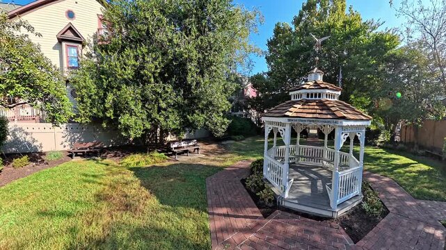 Wide video view reveals garden gazebo during smooth camera motion through Occoquan Virginia.
