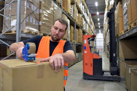workers in a goods warehouse in the retail trade packaged a package with adhesive tape