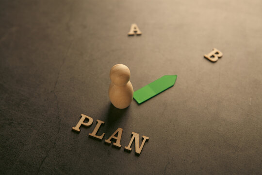 Strategic business planning concept with wooden blocks, hand choosing Plan A over B